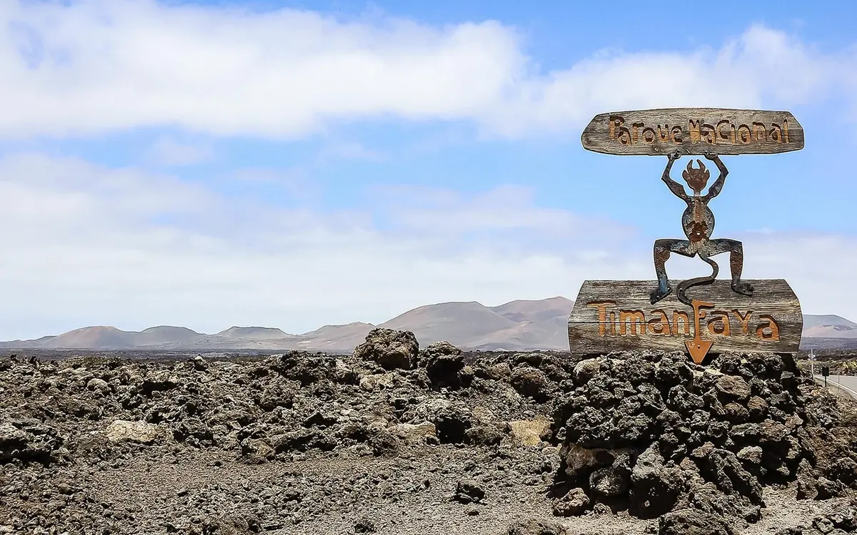 Black volcanic cones and frozen lava flows in the south of Lanzarote under a clear sky